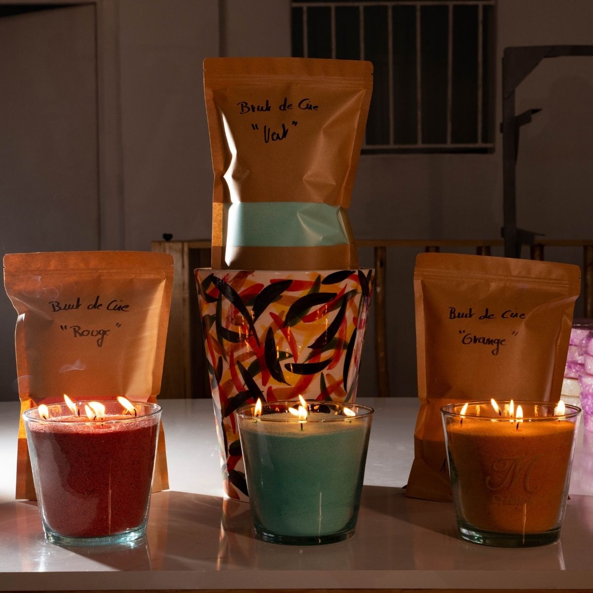 A stunning collection of handmade glass vessels glowing warmly, each filled with vibrant green, red, or orange sand wax. Complete with convenient refill bags, this set from Dary Living blends artisanal craftsmanship with sustainable luxury, offering endless ambiance and color to elevate any space.