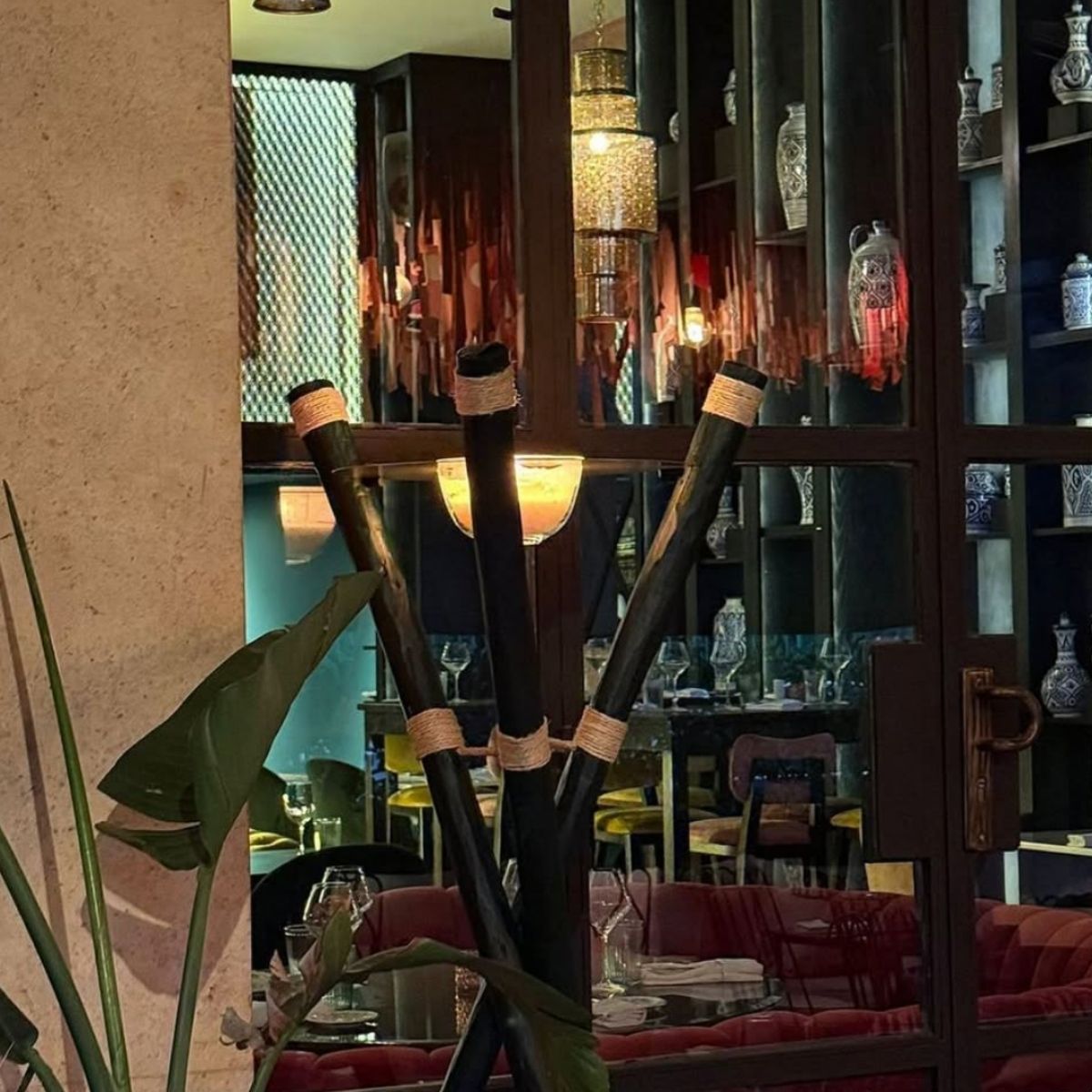 Handcrafted Flambeaux 3 wooden leg stand Olive Green candle at the entrance of a restaurant