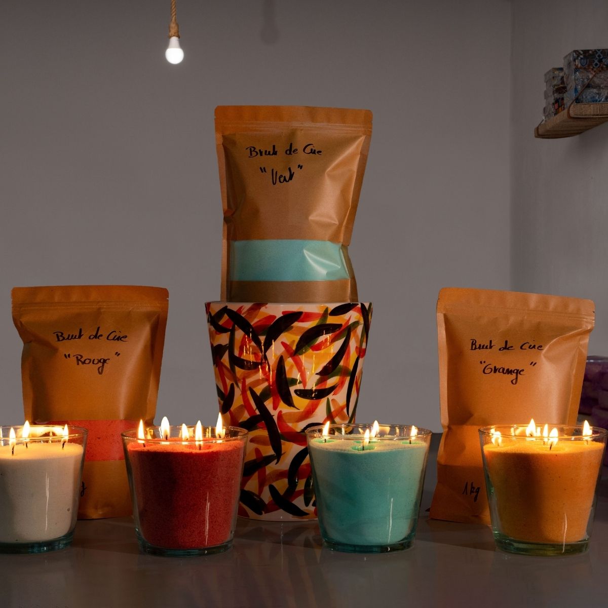 A stunning collection of handmade glass vessels glowing warmly, each filled with vibrant green, red, orange, or white sand wax. Complete with convenient refill bags, this set from Dary Living blends artisanal craftsmanship with sustainable luxury, offering endless ambiance and color to elevate any space.