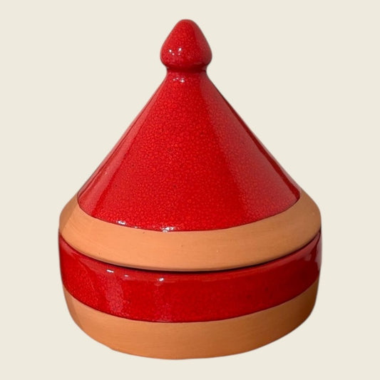 The Clay Tagine Candle is a stunning fusion of tradition and modern artistry — handcrafted in Moroccan red clay with the iconic conical lid. Both the lid and upper half of the vessel are elegantly finished in vibrant red paint, while the bottom remains the warm, natural terracotta clay. Filled with natural wax, this candle brings a bold yet earthy statement to any space, blending cultural heritage with contemporary design.